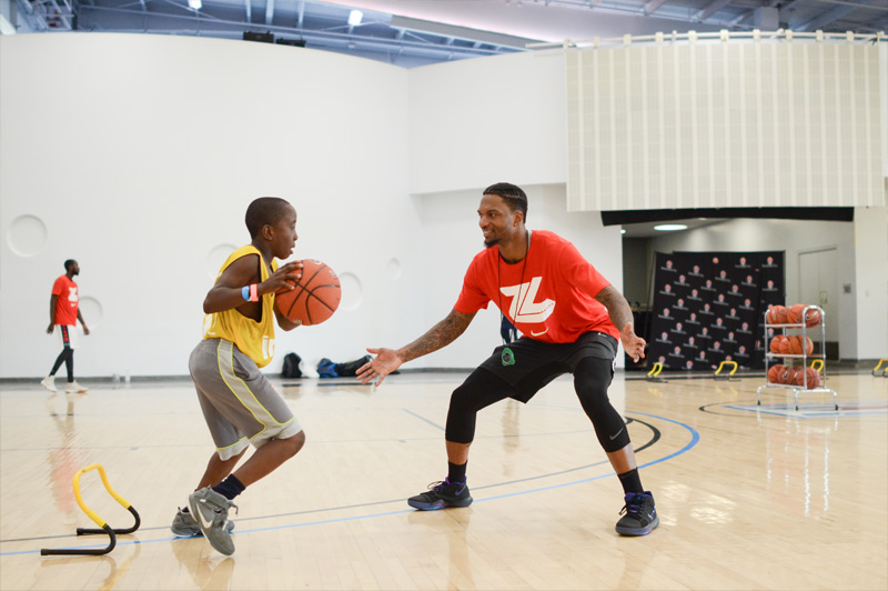 young boy play basketball with his coach
